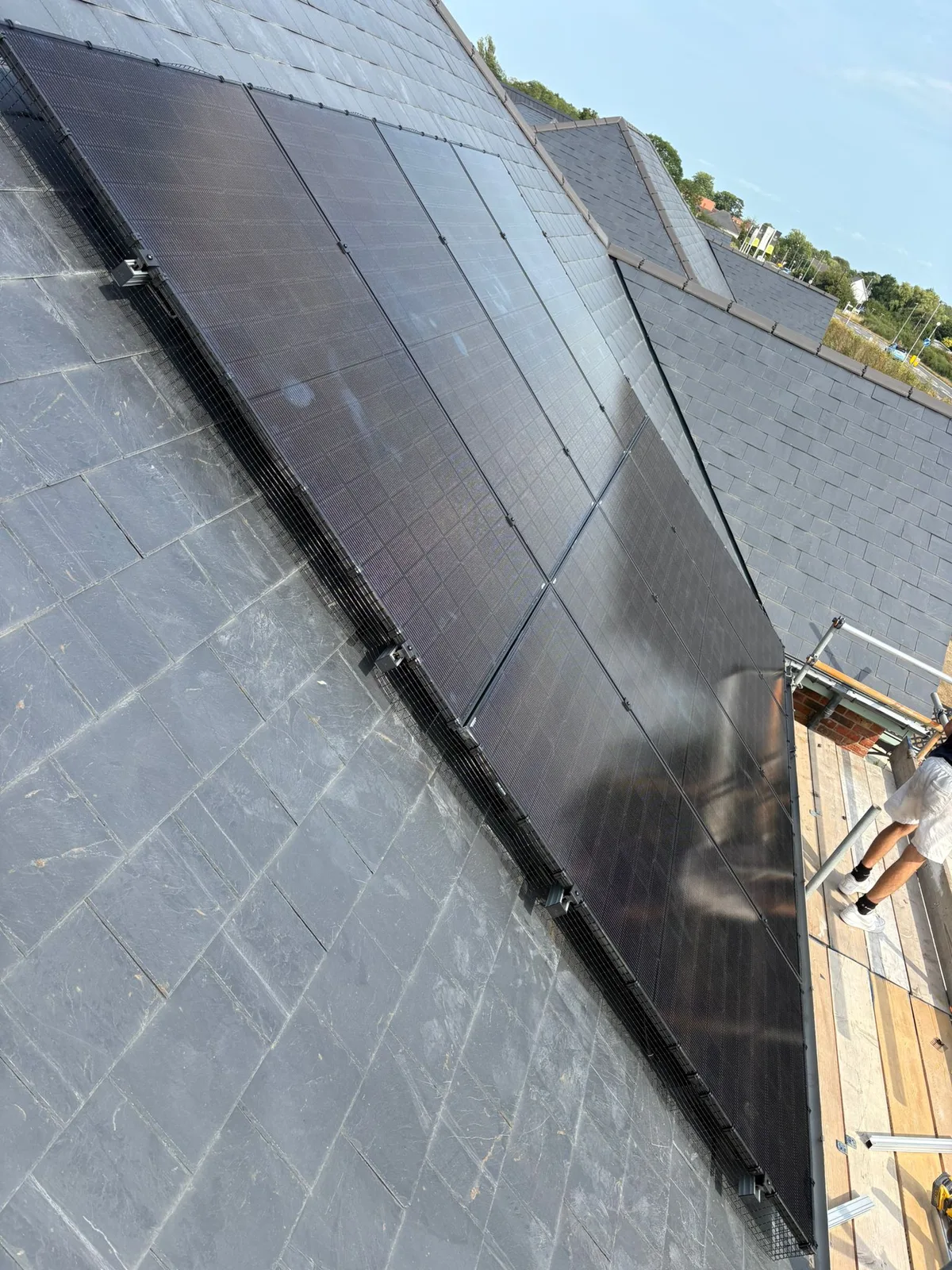 Installers fitting solar panels on a roof